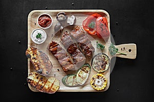 Barbecue Pork Ribs with vegetables on cutting board top view