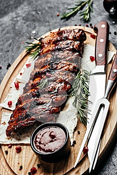 Barbecue Pork Spare Ribs with BBQ sauce on board, vertical image. top view. place for text