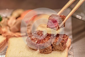 Barbecue rib eye steak, Selected focus on a dry aged Wagyu entrecote steak on chopsticks