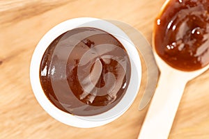 Barbecue sauce in bowl on wooden table