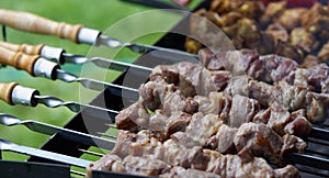 Barbecue shashlik kebab with winglets in chargrill semifinished on skewer side view closeup