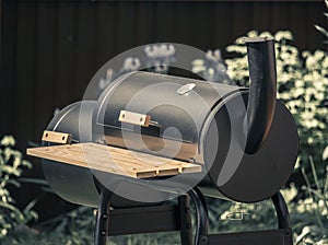 Barbecue with smoke pipe in the summer garden of cottage