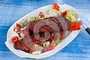 Barbecue spare ribs from a grill with vegetables