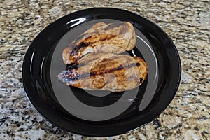 Barbecued Chicken On A Black Plate On Granit Counter