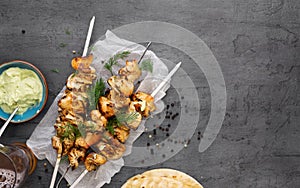 barbecued chicken breast skewers with flat bread and avocado sauce