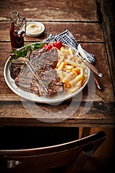 Barbecued or grilled T-bone steak and French fries