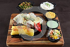 barbecued meat with cassava fried banana rice beans and herb sauce, typical brazilian food