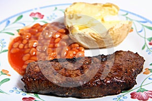 Barbecued sirloin steak baked beans and potato