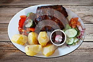 Barbecued spareribs with tomatoes and salad