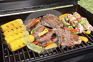 Barbecued steaks, brats, corn and chicken
