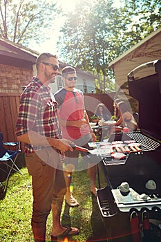 Barbecues are the best. friends having a barbecue outside.