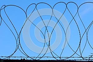 Barbed Razor Wire Military Security Fence Against Blue Sky