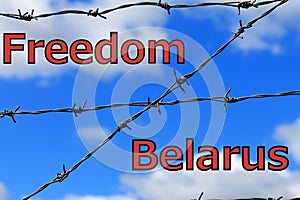 Barbed wire against a background of blue sky and clouds with the inscription - Freedom Belarus. Concept of protests in Belarus