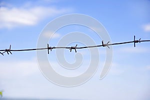 Barbed wire against the blue sky.