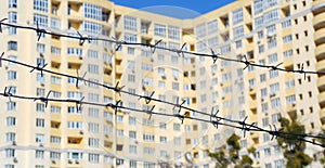 Barbed wire around unfinished building symbolizing crisis in construction industry