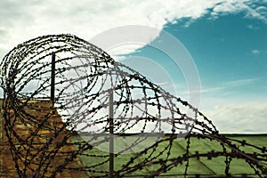 Barbed wire. Barbed wire on blue sky background with white clouds. Wire boom. Military conflict . Syria.