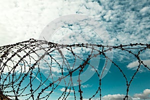 Barbed wire. Barbed wire on blue sky background with white clouds. Wire boom. Military conflict . Syria.