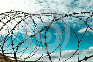 Barbed wire. Barbed wire on blue sky background with white clouds. Wire boom. Military conflict . Syria.