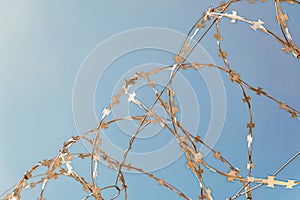 Barbed wire close-up on a blue sky background photo