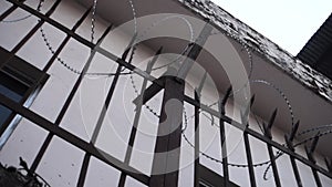 Barbed wire enclosure outside a building with metal grill