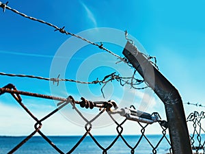 Barbed wire fence against blue sky, imprisonment and captivity concept photo