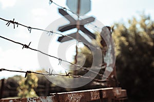 Barbed wire fence against dramatic, dark sky. City road street sign