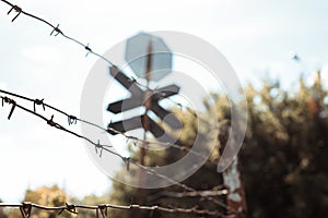 Barbed wire fence against dramatic, dark sky. City road street sign