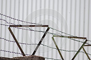 Barbed wire fence as protection and no trespassing safety symbol and warning for defense and military razor sharp security for jai