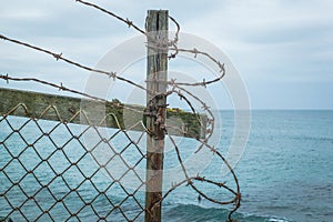 Barbed wire fence on ocean clifftop