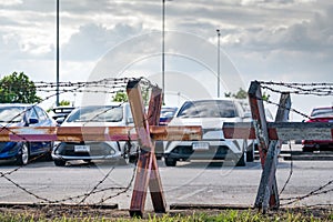 Barbed wire fence of the parking lot. Cars parked at outdoor car parking lot. Car was seized by a lending company. Financial photo