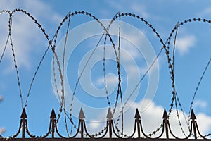 Barbed wire on fence, steel grating fence with barbs