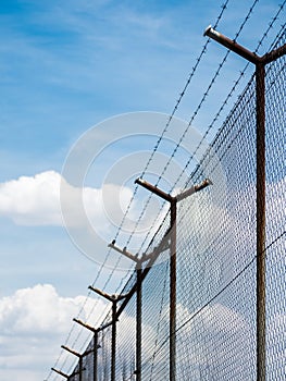 Barbed wire fence under the sky background