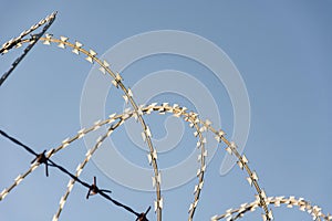 Barbed Wire Fence Used For Protection Purposes Of Property And Imprisonment, No Freedom, Barbed Wire On fence With Blue Sky To