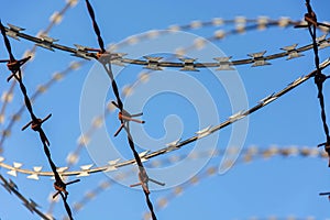 Barbed Wire Fence Used For Protection Purposes Of Property And Imprisonment, No Freedom, Barbed Wire On fence With Blue Sky To