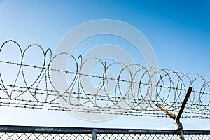 Barbed Wire Fence Used For Protection Purposes Of Property And Imprisonment, No Freedom, Barbed Wire On fence With Blue Sky To