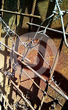 Barbed wire on metal reinforcement on a background of rusty iron.