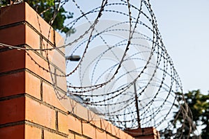 Barbed wire over a brick fence