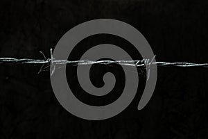 Barbed wire over dark grungy background