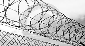 Barbed wire over a metal fence - security or reclusion concept