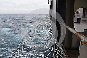 Barbed wire or razor wire attached to the ship hull, superstructure and railings to protect the crew against piracy attack. photo