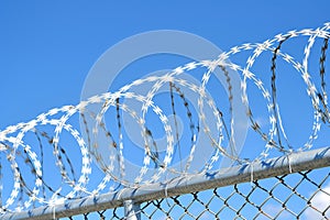 Barbed wire securely placed on the top of a concrete fence wall for heightened security measures photo