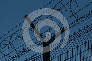 Barbed wire steel fence against the immigrants in europe. Restricted area at night. photo