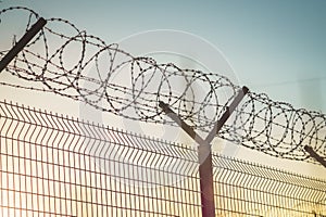 Barbed wire steel fence against the immigration in europe. Restricted area. photo