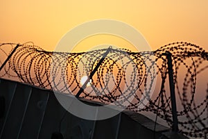 Barbed wire on sunset sky background