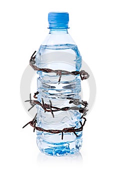 Barbed wire surrounding bottle of water photo