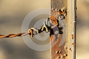 barbed wire tied to a metal pole with background out of focus