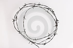Barbed wire on a white background. Close-up, with sharp spikes arranged in a circle. copy space