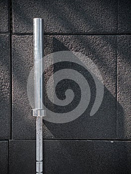 A barbell on an exercise mat with dramatic shadows