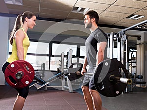 Barbell man and woman workout at fitness gym