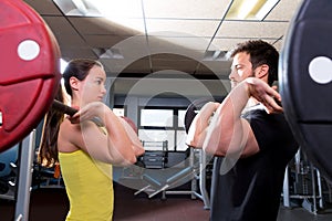 Barbell man and woman workout at fitness gym